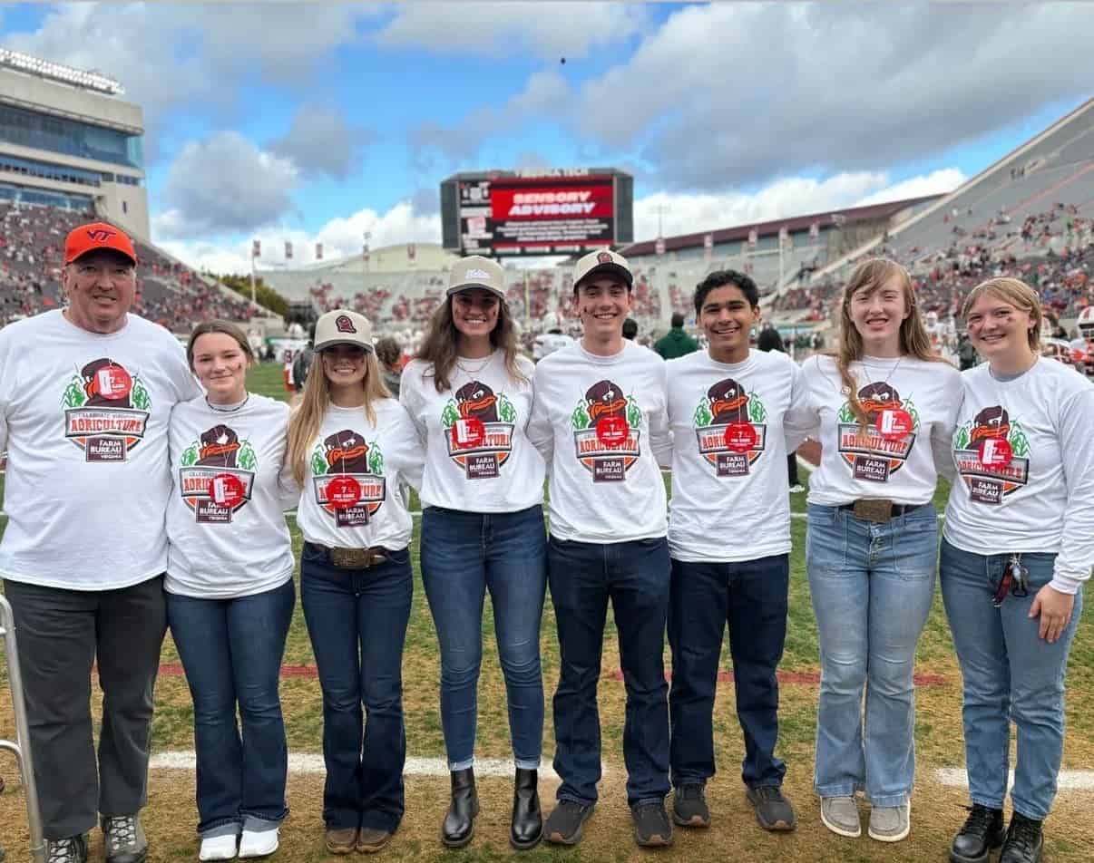 Virginia FFA State Officers Danika Landreth, Kylie Bailey, Emma Alexander, Lee Kent, Franco Abud, Georgia Grady, and Alli Phillips along with Mr. Andy Seibel wearing their FFA Game Day shirts.
