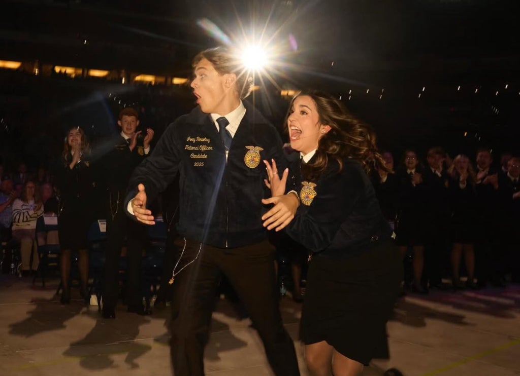Newly elected National FFA Eastern Region Vice President races toward the stage alongside predecessor Caroline Groth.