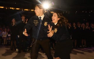 Newly elected National FFA Eastern Region Vice President races toward the stage alongside predecessor Caroline Groth.