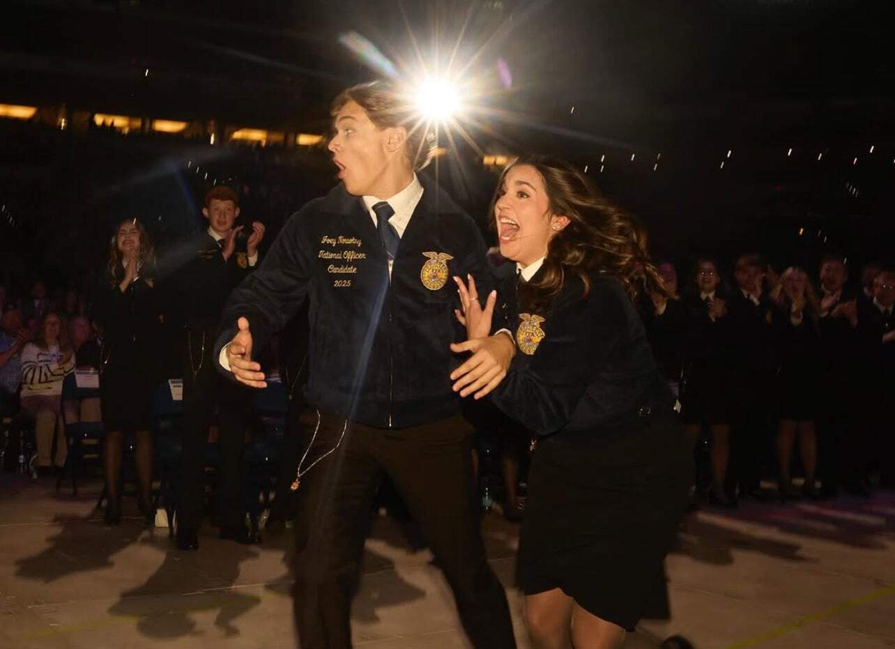 Newly elected National FFA Eastern Region Vice President races toward the stage alongside predecessor Caroline Groth.
