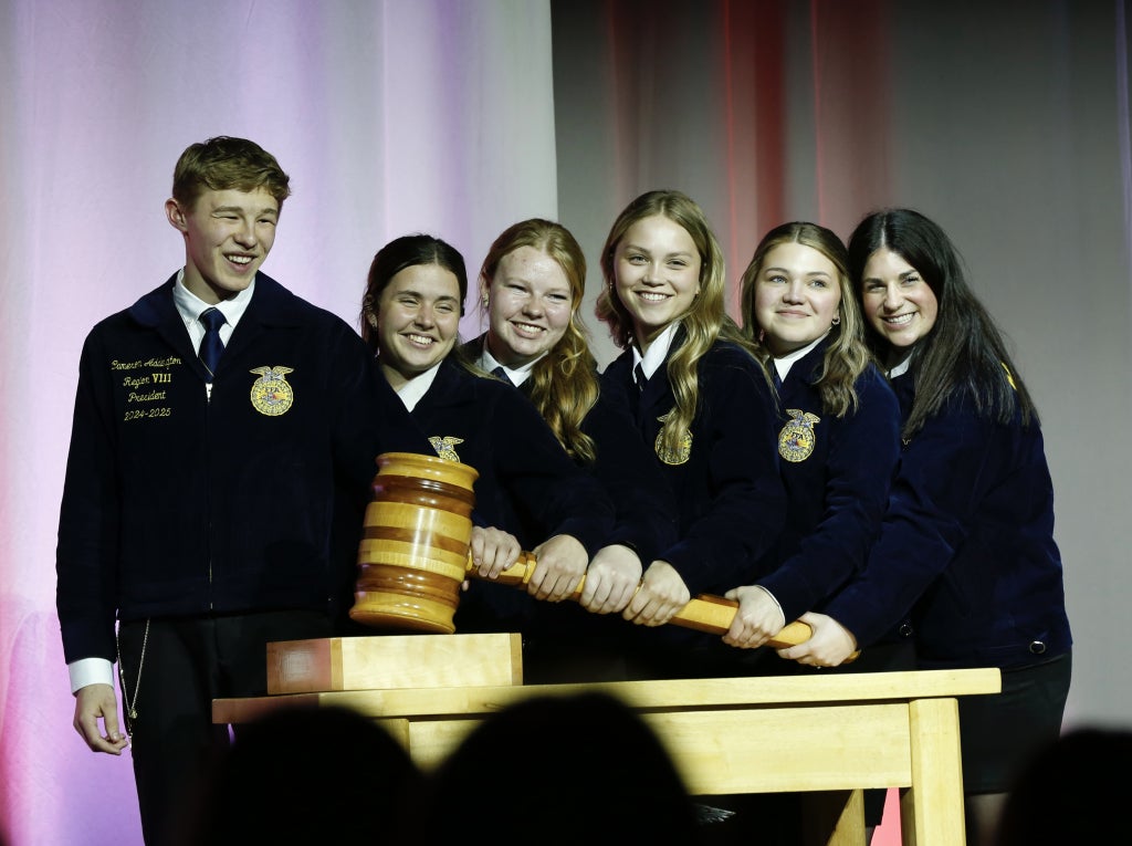 Minnesota FFA state officers tap the gavel together at the Minnesota State Leadership Convention.