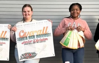 Four team members from the Junior and Senior Division Livestock Evaluation NECP teams are seen with their placements of the season.