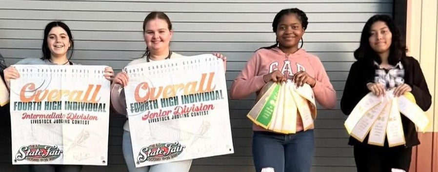 Four team members from the Junior and Senior Division Livestock Evaluation NECP teams are seen with their placements of the season.