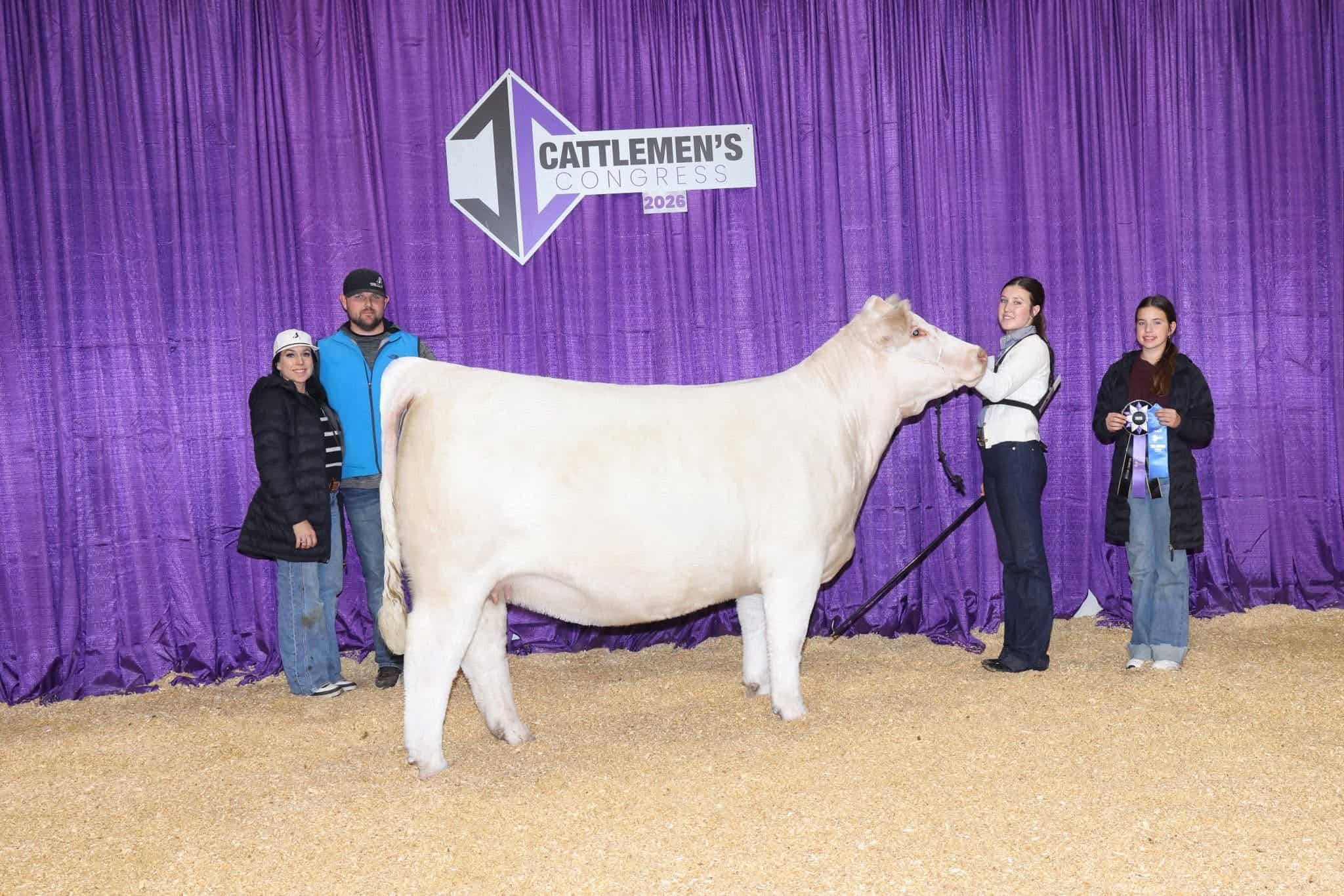 Young students and judge showcasing a prize-winning cattle at FFA National Convention.
