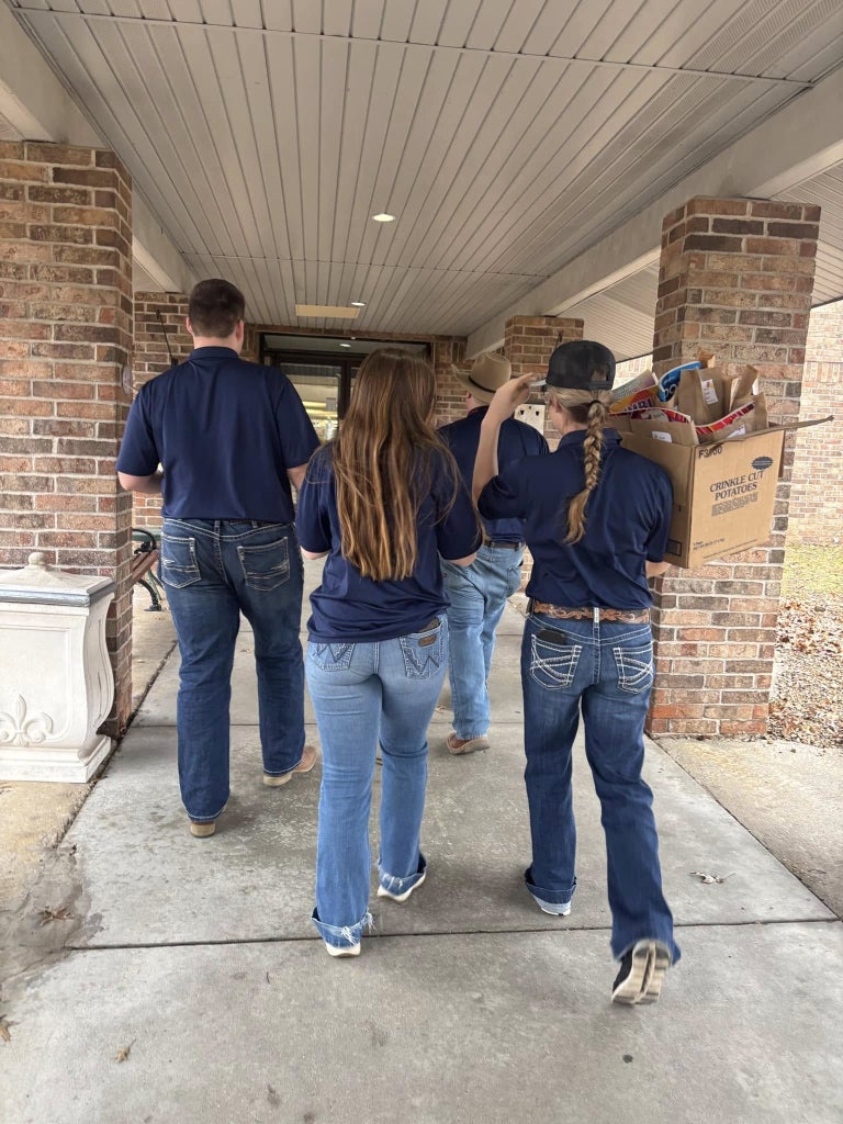 Blake Herring (left), Rylee Nichols (middle) and Ellah Chesik (right) carry boxes into the care home.
