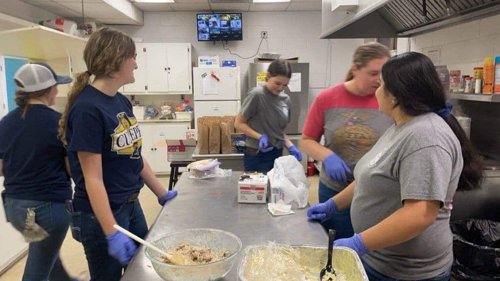 2024-25 Culpeper County FFA Chapter Officers Danika Landreth (student advisor), Madison Stephens (vice president), Nicole Saldana (vice president) and Avah Bache (president), joined by Chapter Advisor Laura DeLano and member Savannah Landreth, prep meals during their annual visit to Saint Luke’s Warming Shelter.