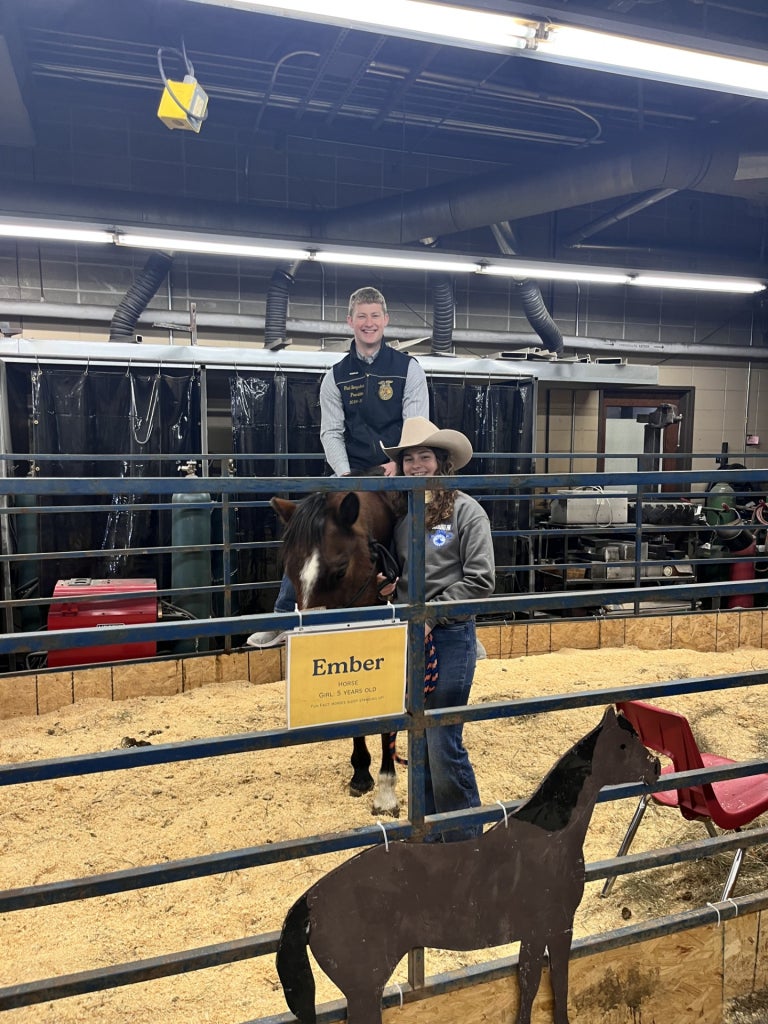 2024-25 National FFA President Thaddeus Bergschneider (left) riding the nursery horse, Ember, with Josie Nold (right).
