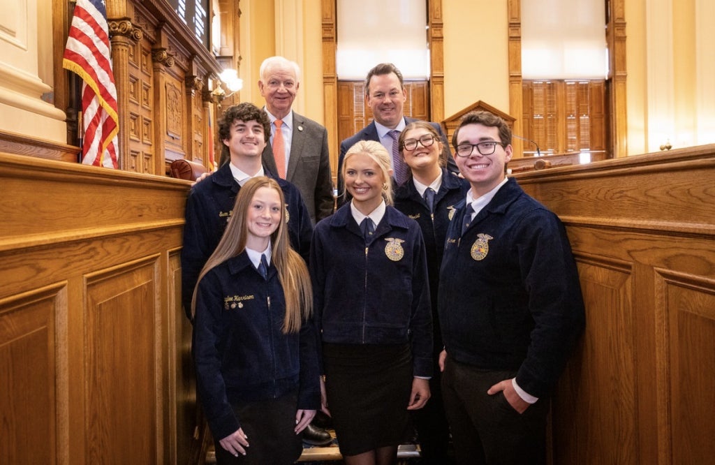 Members stand on the floor of the state senate with Senator Max Burns and Lieutenant Governor Burt Jones.