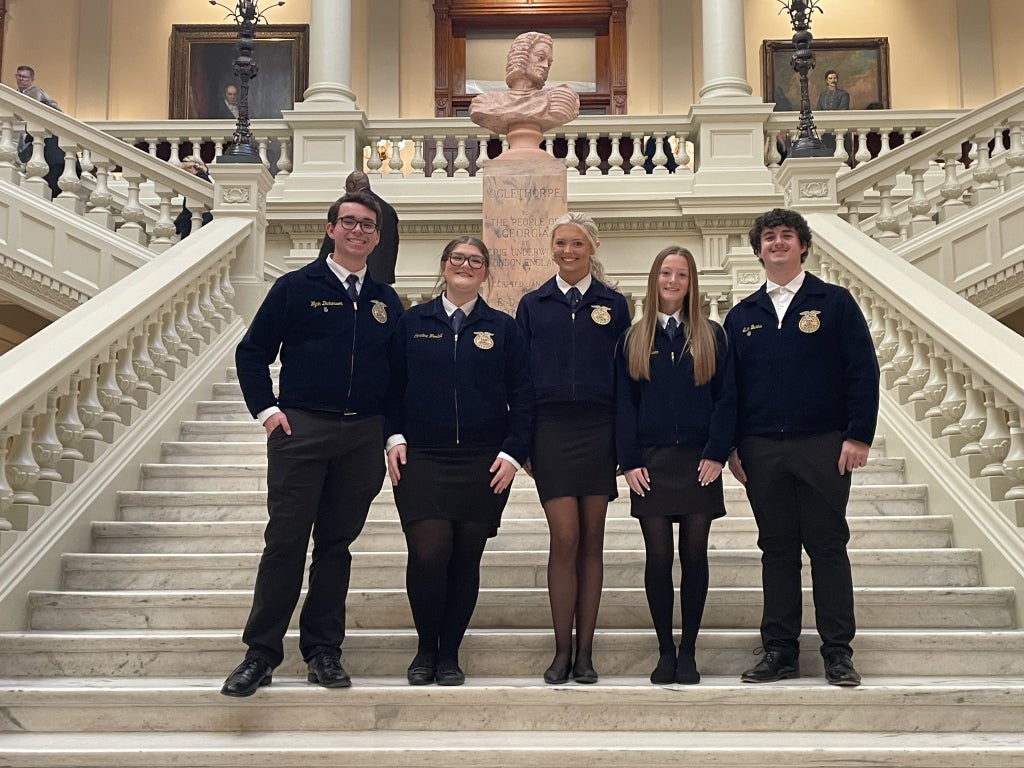 Members stand on the north steps of the Georgia State Capitol.