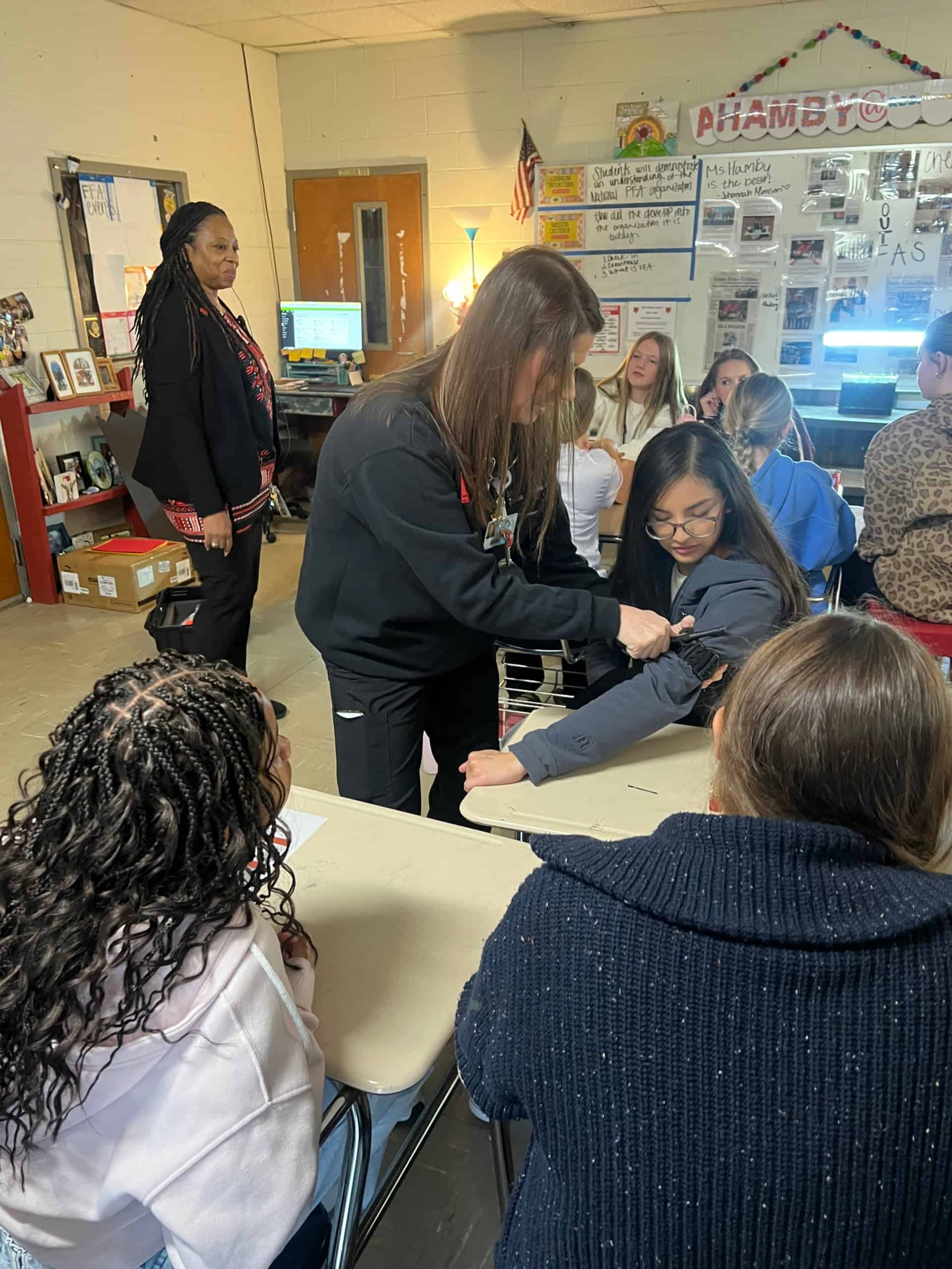 An Atrium Health nurse shows a demonstration on a student.