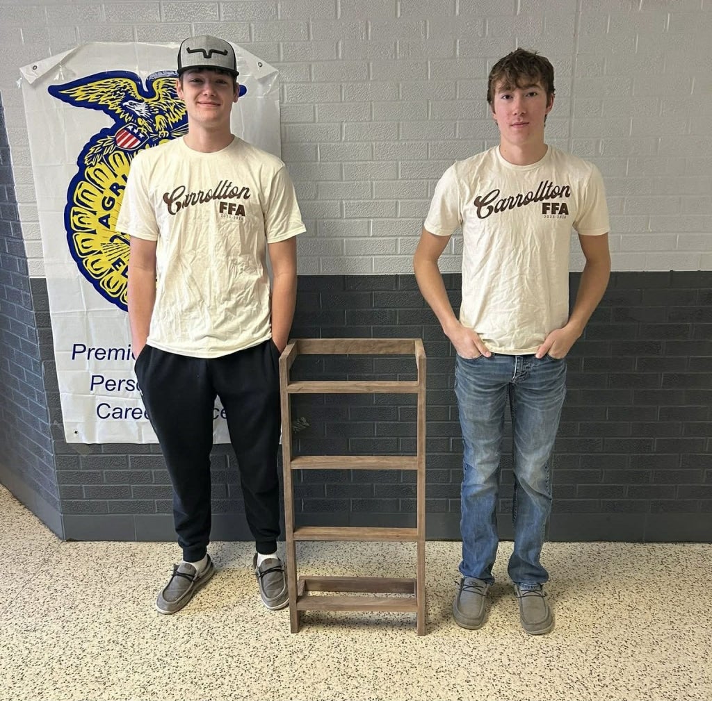 Jackson Davis and Carter Germann stand beside the blanket rack they crafted and donated to the Help Cancer Fund Auction, showcasing their generosity and devotion to supporting local families.