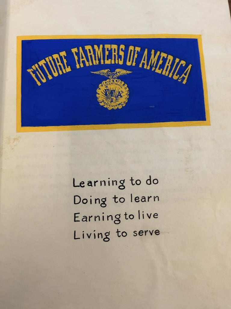 The front page of the South Hill FFA Chapter scrapbook is illustrated with past FFA branding, as well as the motto that still stands today.