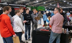 Members of the Patrick Henry FFA chapter talk with an exhibitor.