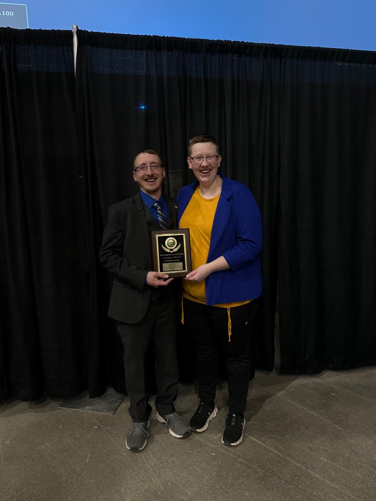 Brookings FFA advisors Mr. Joshua Johnson and Mrs. Michelle Dykstra pose with their 3-Star Chapter Award at the 98th National FFA Convention & Expo.