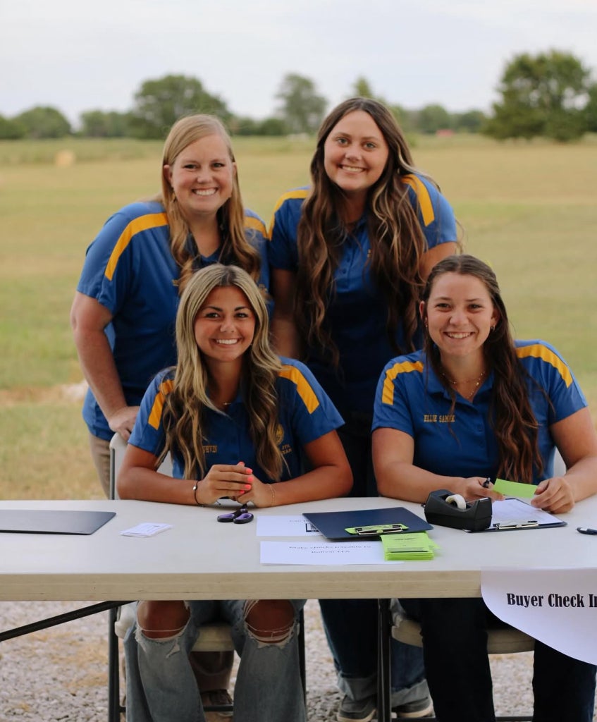 Mrs. Brown with three of her students at the Bolivar FFA Labor Auction.