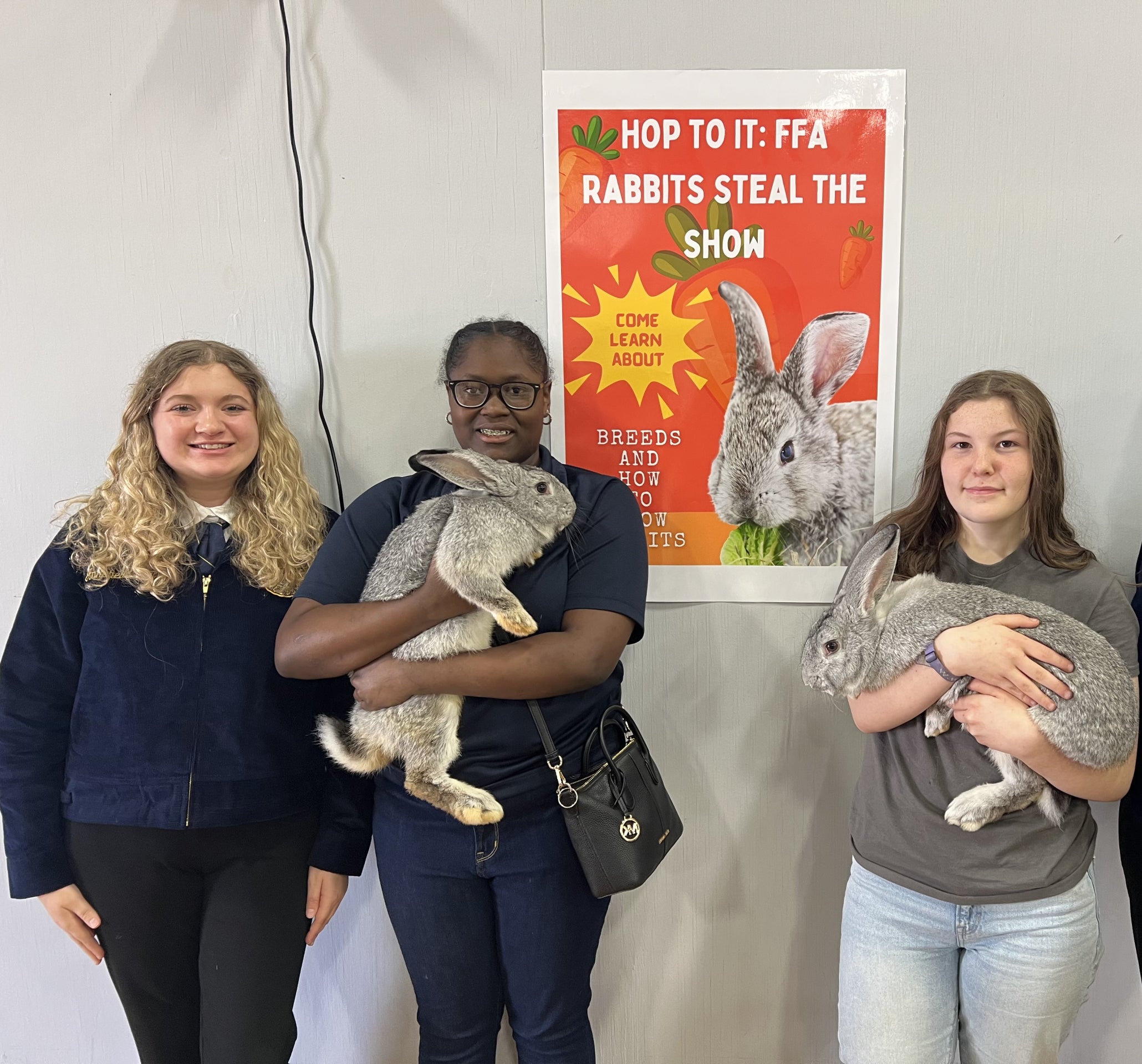Delhi Charter FFA show team members Kaydence Daniels and Maddie Wilkins show their rabbits at the annual DCS STEM Day, along with President Annabelle Olivoe, to inform participants about rabbit care and opportunities within the National FFA Organization.