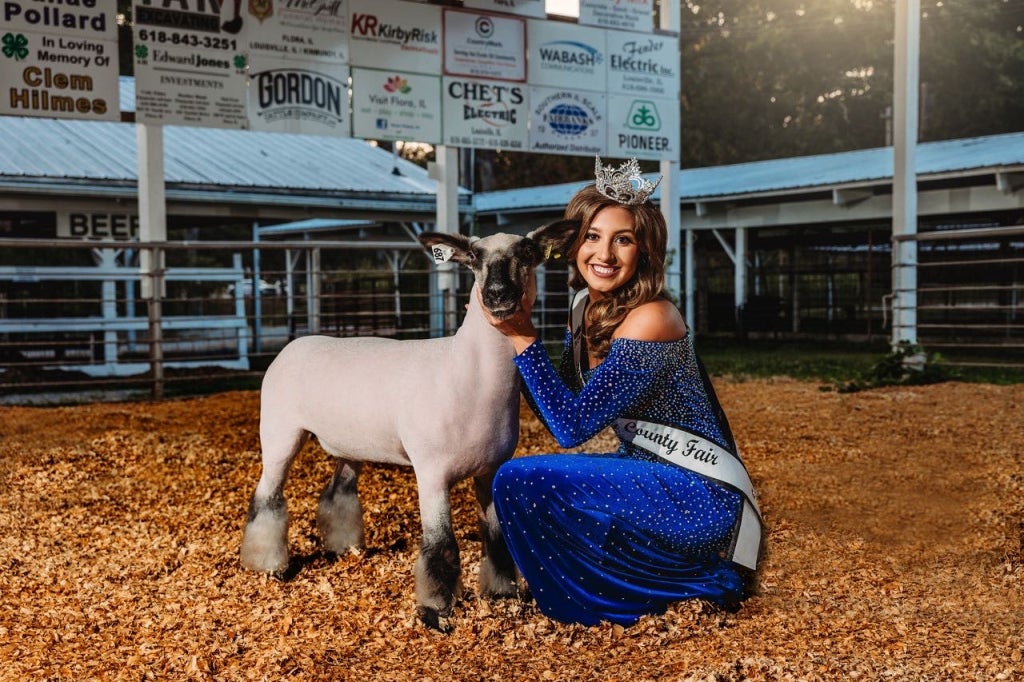 Paris Van Dyke in her queen attire with her sheep at the Clay County Fair.
