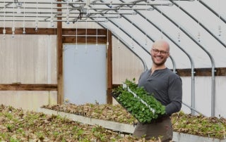 Drew poses with a flower grown at Clara Joyce Flowers.