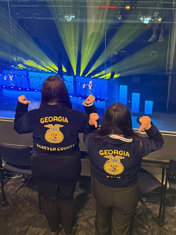 Coraline Woodall and I point at our FFA jackets at National FFA Convention.