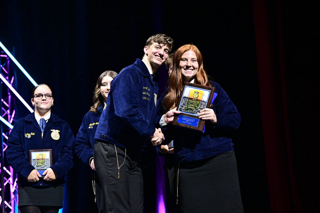 Maggie Taylor receiving her first-place plaque in outdoor recreation at the 2025 Indiana FFA State Convention.