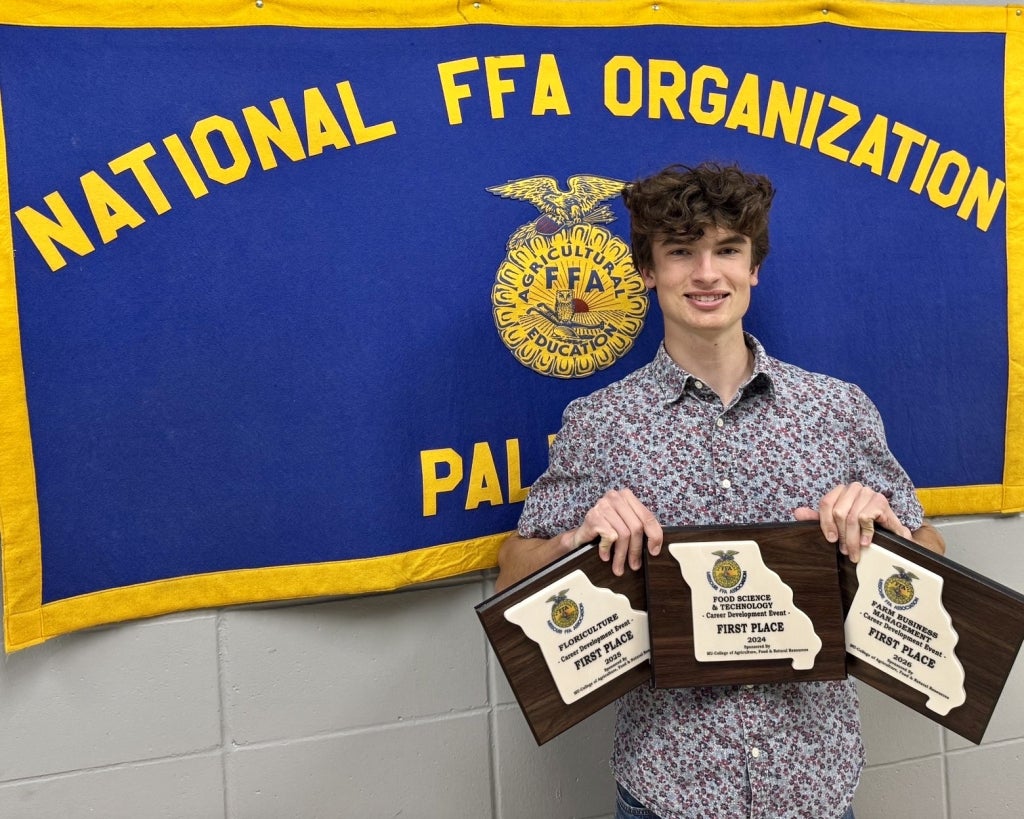 Summers holding first-place state plaques for food science, floriculture and and farm management.