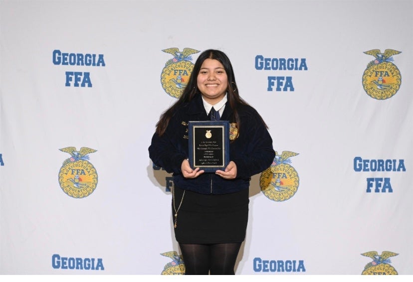 Lilia Mendez holding her ambassador plaque at the Georgia FFA Convention.