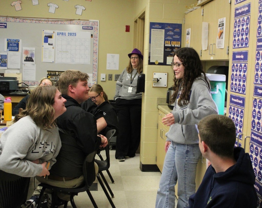 Raine Wheeler giving a speech to a classroom full of FFA members.