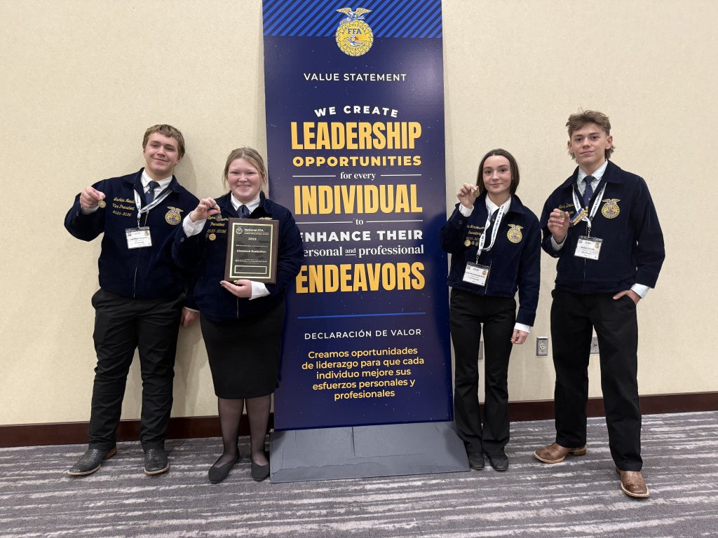Livestock evaluation team members pose for a photo with their plaque and medals.