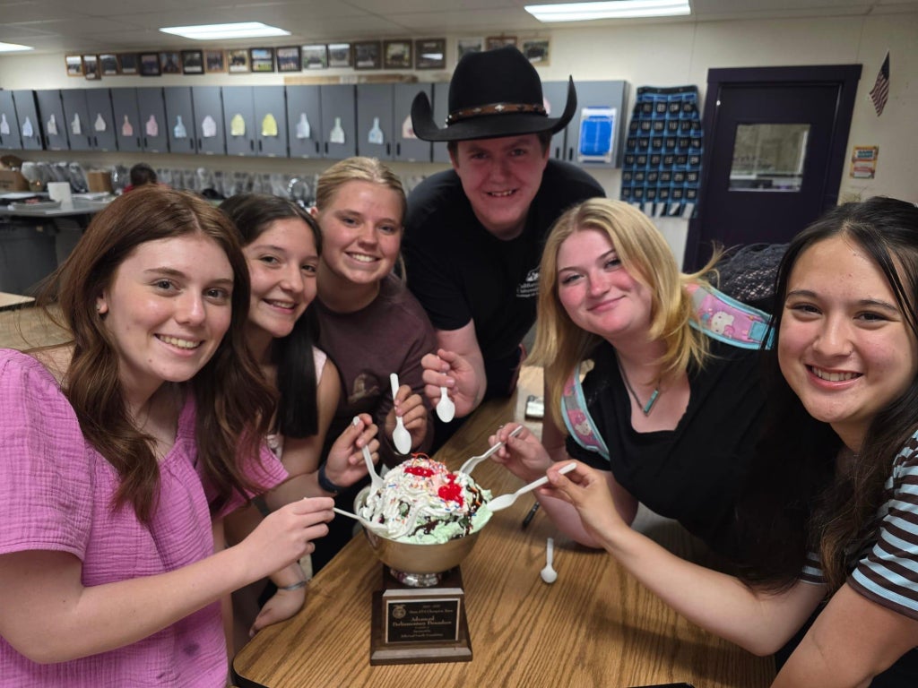 The Susanville FFA Chapter’s Advanced Parliamentary Procedure Team eating ice cream out of its state champion bowl.