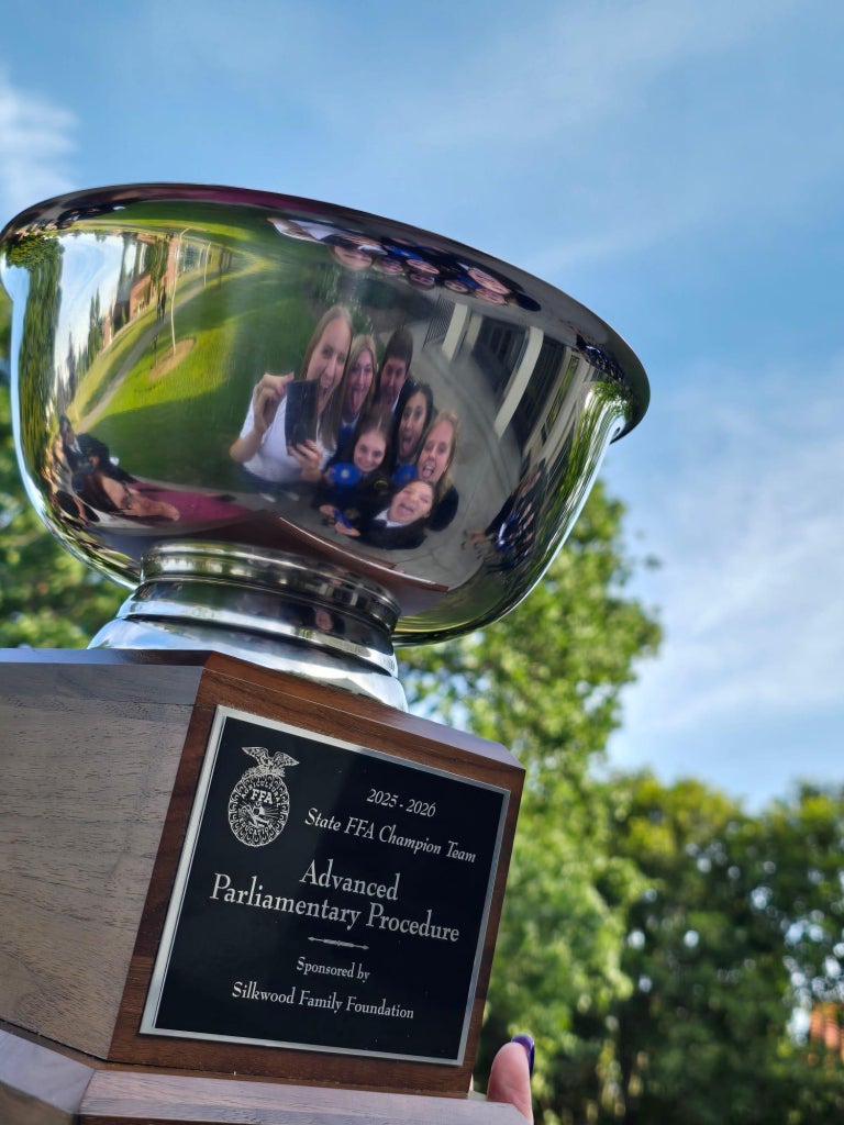 The Susanville FFA Chapter’s advanced parli team taking a picture of its reflection in the state champion bowl.