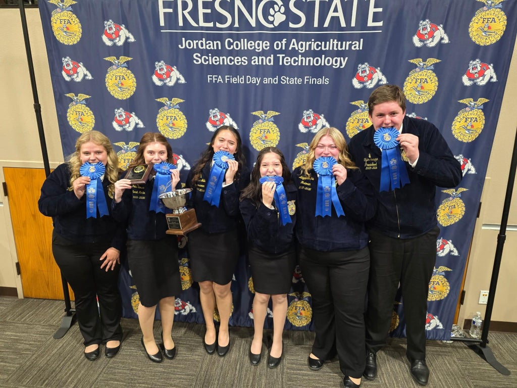 Susanville FFA holding its team state champion ribbons and bowl.
