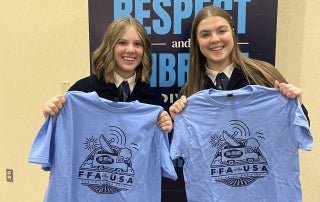 Illinois FFA in the USA Reporters, Mila Zink and Savannah Cycholl show off their reporter tee shirts at the 98th National FFA Convention & Expo.