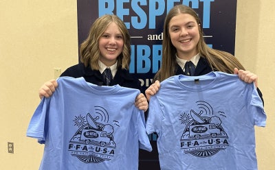Illinois FFA in the USA Reporters, Mila Zink and Savannah Cycholl show off their reporter tee shirts at the 98th National FFA Convention & Expo.