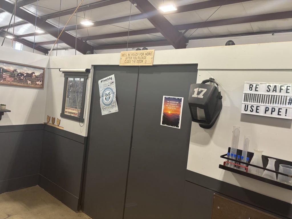 The image features interactive components of the escape room, such as cryptic puzzles and the welding helmet. 