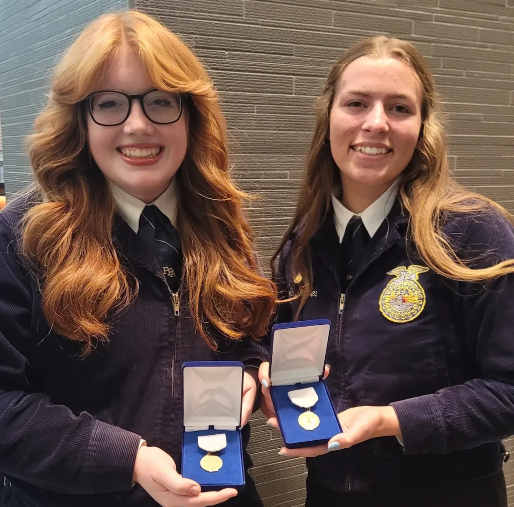 Bailey Ham and Molly Fowler holding their medals after placing third at nationals in National FFA Agriscience Fair Social Science Division VI.