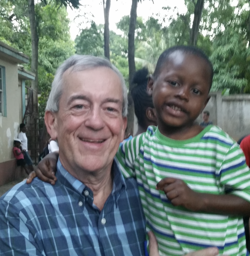 Dr. Mark Russell connects with a young orphan during a study abroad experience in Cap-Haïtien, Haiti