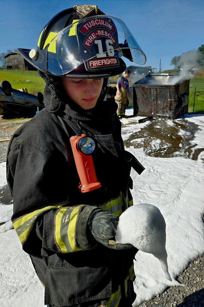 Dakine Thompson holds SoyFoam in his gloved hand during a live fire demonstration at Debusk Volunteer Fire Department.