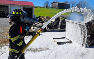 Dakine Thompson, a junior member of Tusculum Volunteer Fire Department, applies SoyFoam during a live fire demonstration.